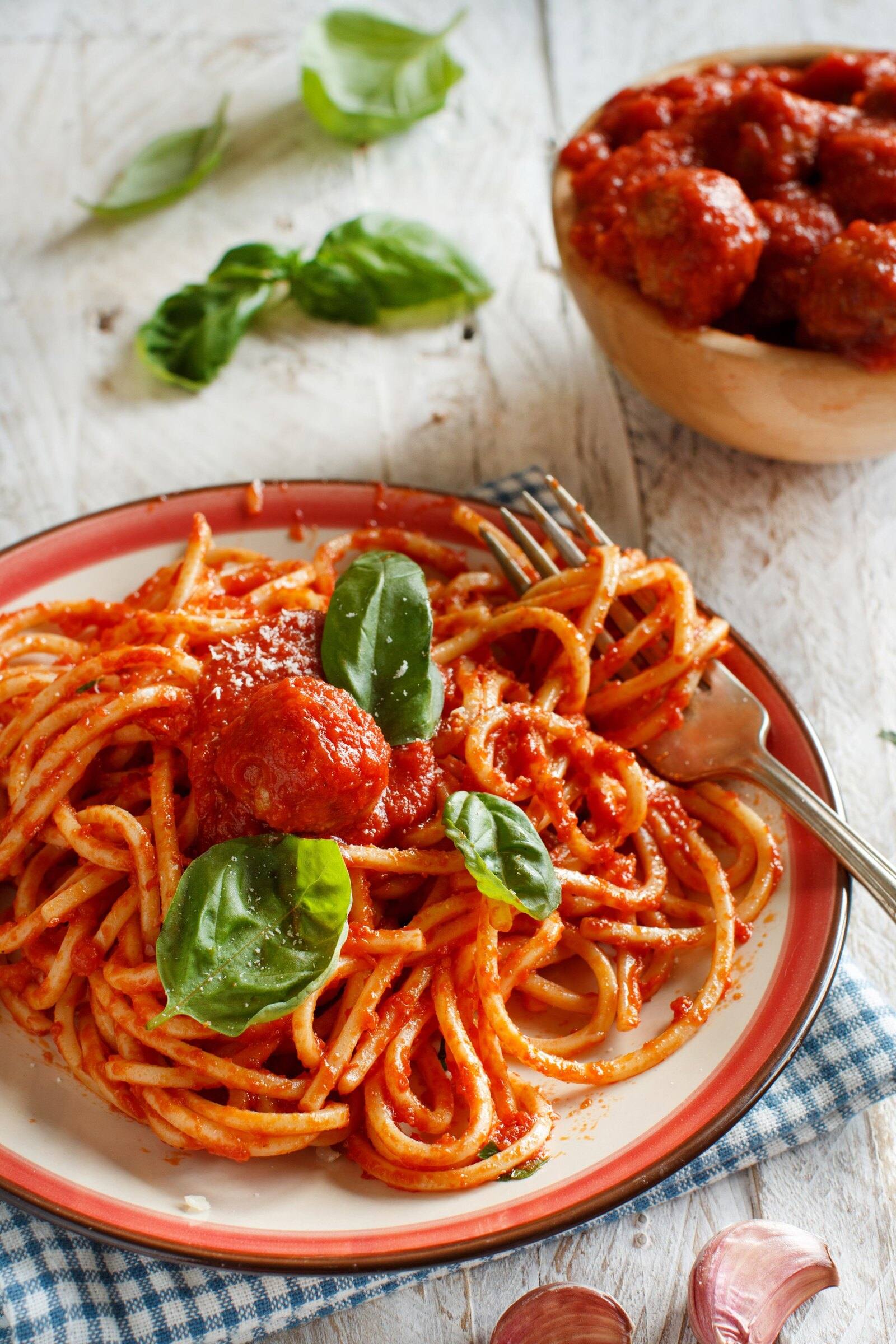 Spaghetti in pomodoro sauce with a meatball and fresh basil